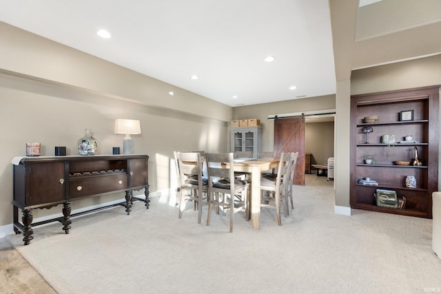 carpeted dining area featuring a barn door