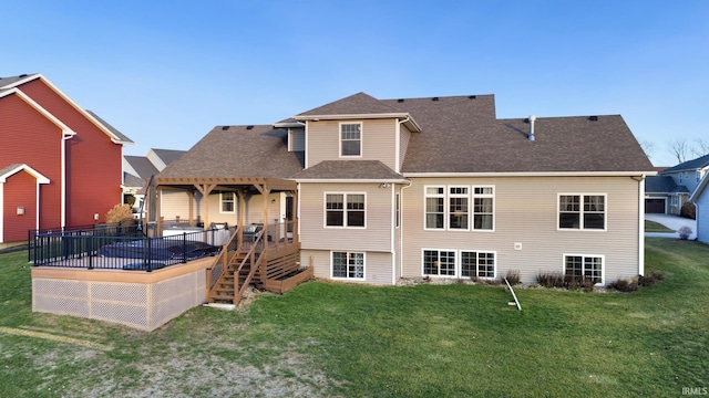 rear view of house featuring a deck and a yard