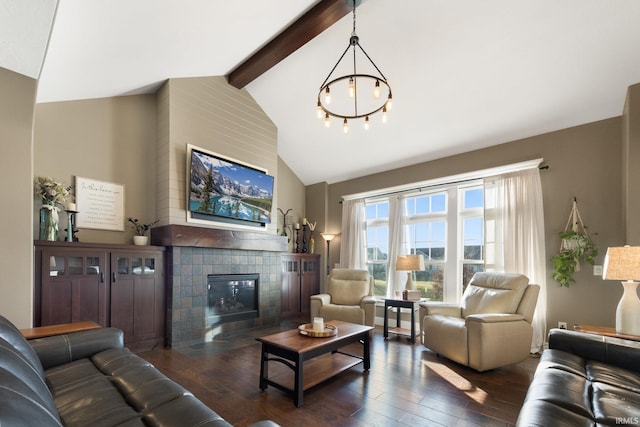 living room featuring a tile fireplace, dark hardwood / wood-style flooring, lofted ceiling with beams, and an inviting chandelier