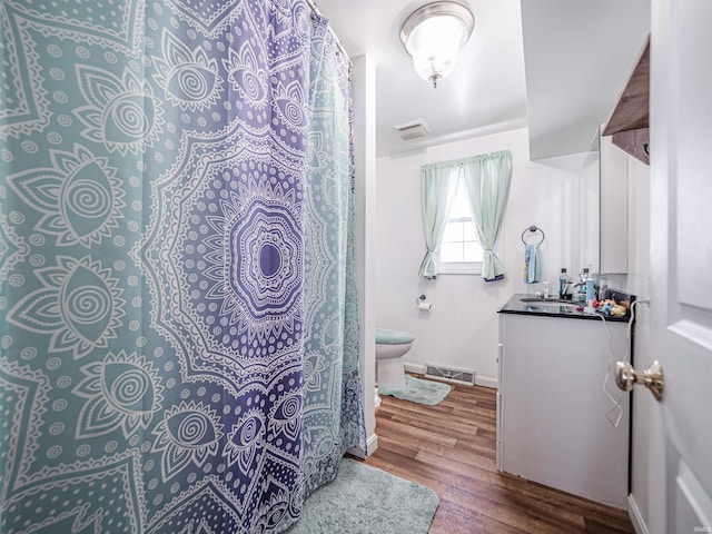 bathroom featuring hardwood / wood-style flooring, vanity, and toilet