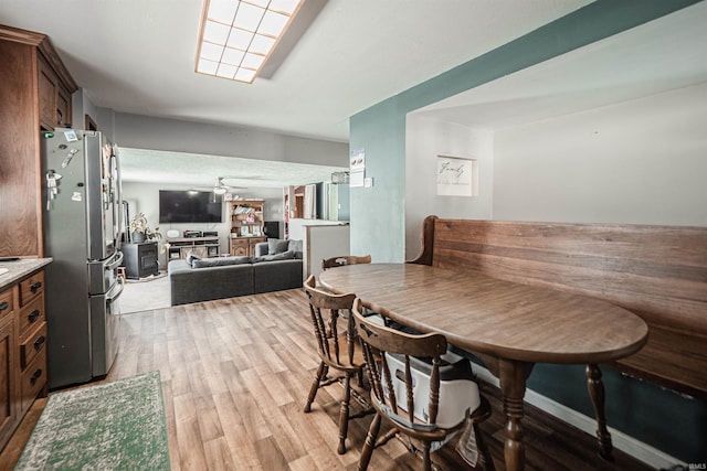 dining space with light hardwood / wood-style floors and ceiling fan