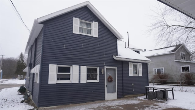 view of snow covered rear of property