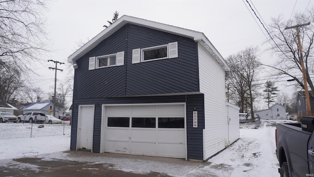 snow covered property with a garage