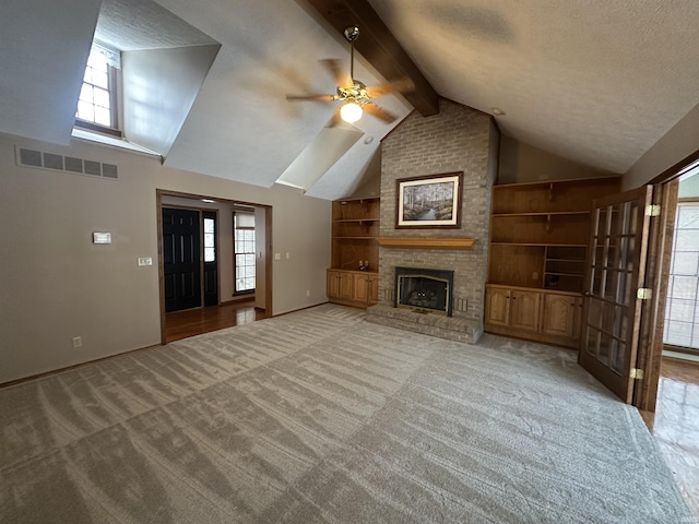 unfurnished living room with plenty of natural light, built in features, and a textured ceiling