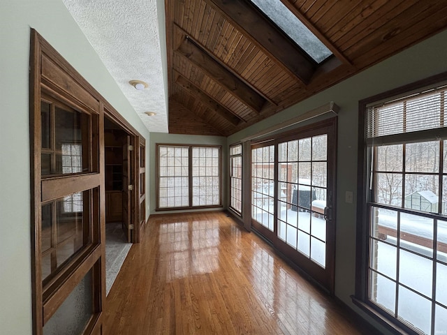 unfurnished living room with lofted ceiling with skylight, hardwood / wood-style floors, and wooden ceiling