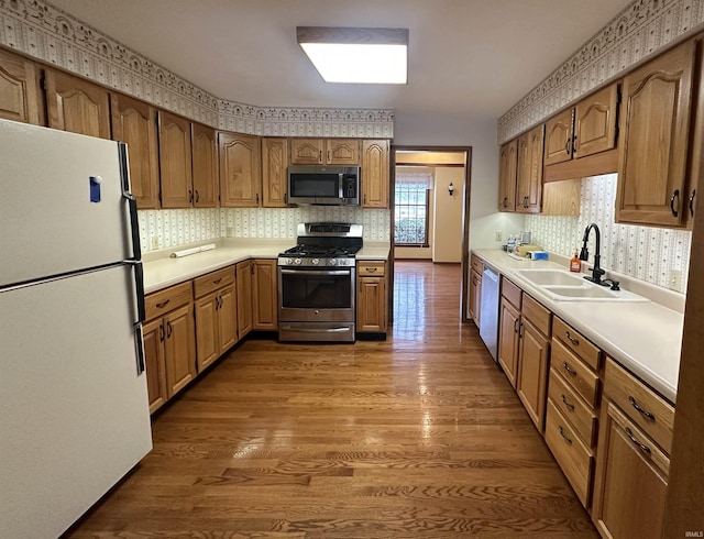 kitchen with sink, wood-type flooring, and stainless steel appliances