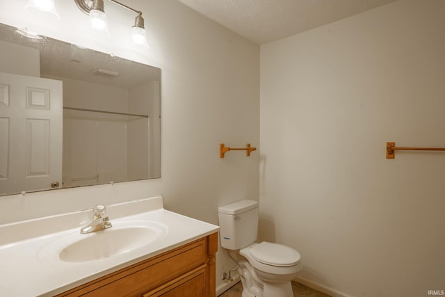 bathroom with vanity, a textured ceiling, and toilet