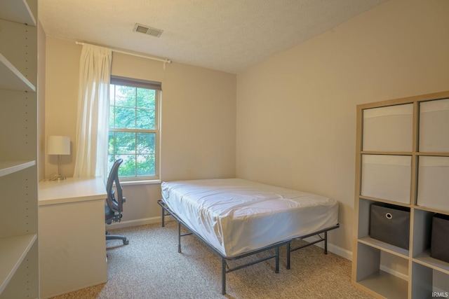 carpeted bedroom featuring a textured ceiling