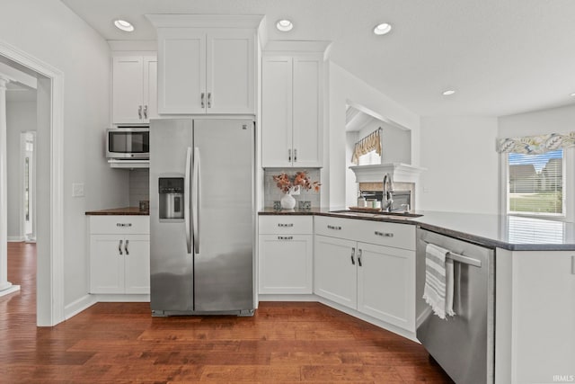 kitchen featuring stainless steel appliances, white cabinetry, dark hardwood / wood-style floors, and sink