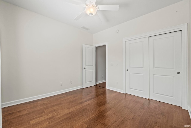 unfurnished bedroom with ceiling fan, a closet, and dark wood-type flooring