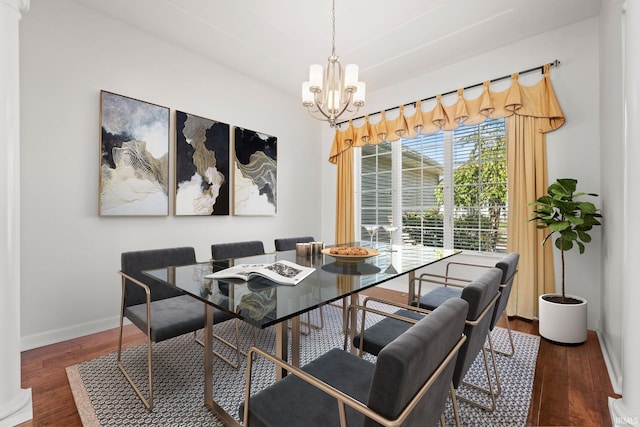 dining area featuring dark wood-type flooring and a chandelier