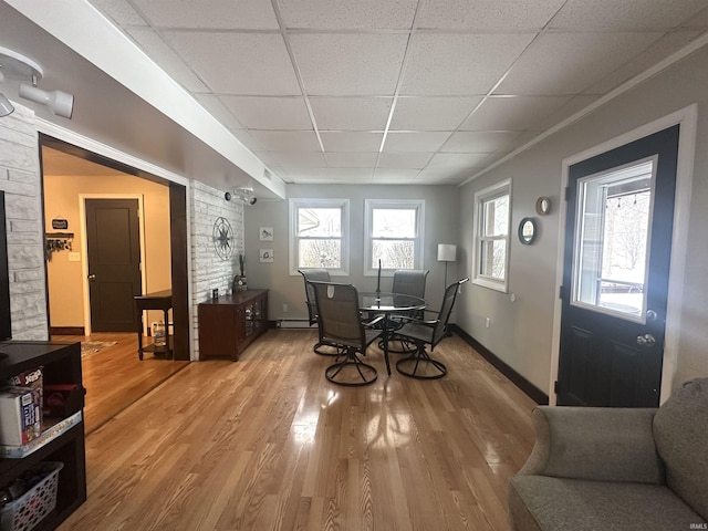 dining room featuring a paneled ceiling and hardwood / wood-style flooring