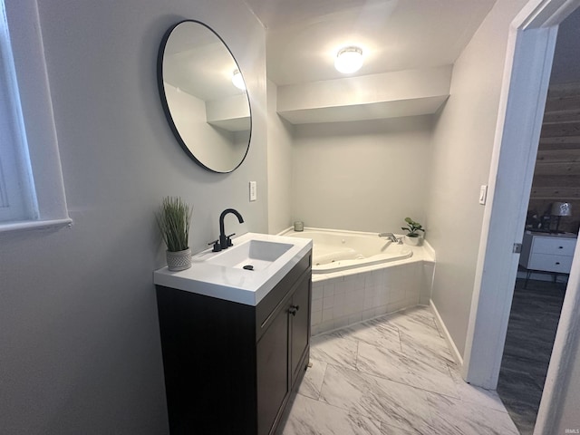 bathroom featuring vanity and tiled tub