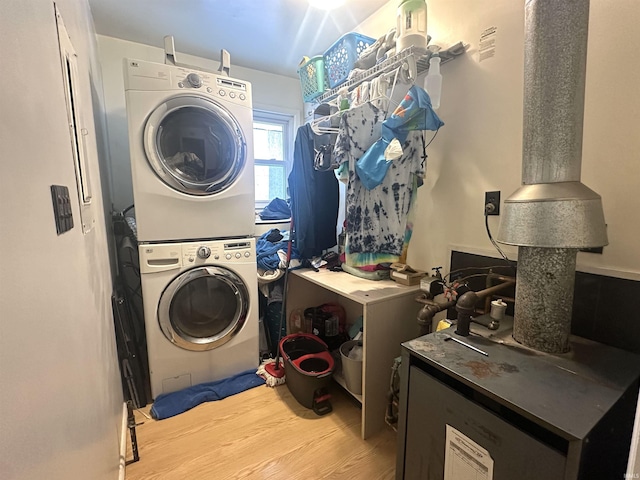 washroom featuring stacked washer / dryer and light hardwood / wood-style flooring