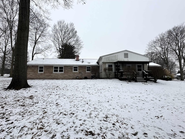 view of snow covered rear of property