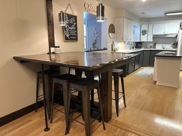 kitchen with white cabinets, a kitchen bar, and kitchen peninsula