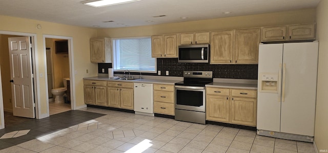 kitchen featuring backsplash, sink, light tile patterned floors, and stainless steel appliances