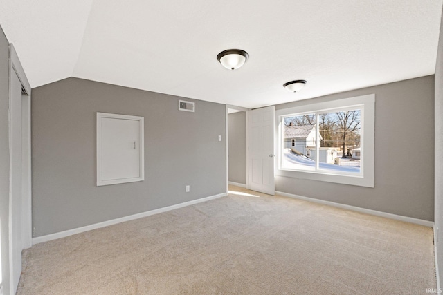 empty room with light carpet and lofted ceiling