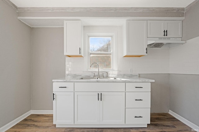 kitchen with white cabinets, tasteful backsplash, and sink