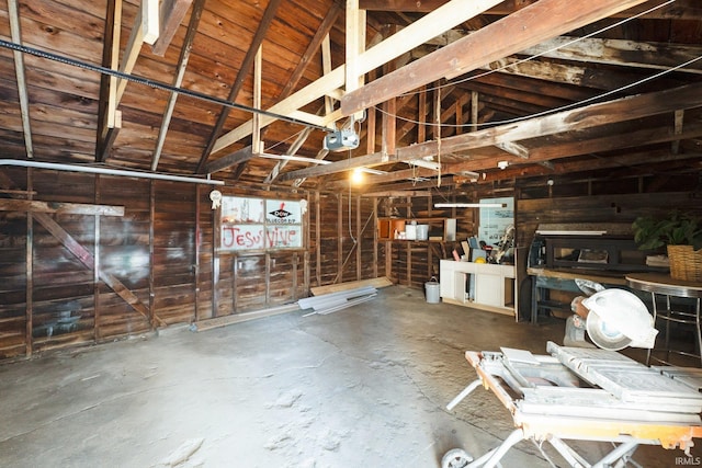 garage with wooden walls and a garage door opener