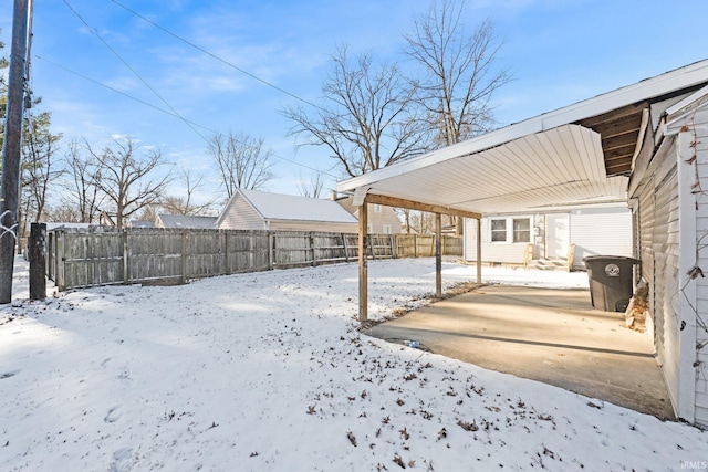 yard covered in snow with a carport