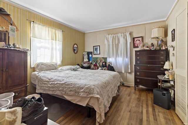 bedroom featuring wood finished floors and ornamental molding