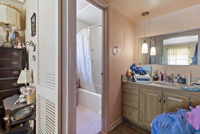 bathroom featuring baseboards, shower / tub combo with curtain, and vanity