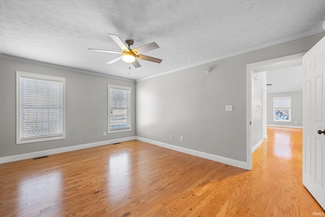 spare room with ceiling fan, light hardwood / wood-style floors, a textured ceiling, and ornamental molding