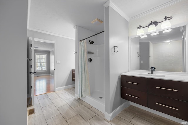 bathroom with crown molding, vanity, and walk in shower