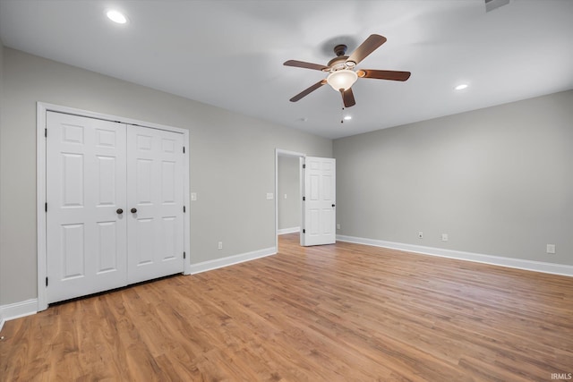 unfurnished bedroom with ceiling fan, light hardwood / wood-style floors, and a closet