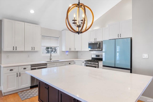 kitchen featuring white cabinetry, sink, an inviting chandelier, and appliances with stainless steel finishes