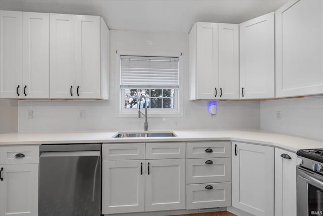 kitchen with tasteful backsplash, white cabinetry, sink, and stainless steel appliances