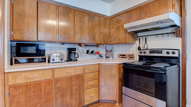 kitchen featuring decorative backsplash, light hardwood / wood-style flooring, and stainless steel electric stove