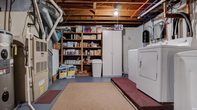 basement with washing machine and dryer, electric water heater, and heating unit