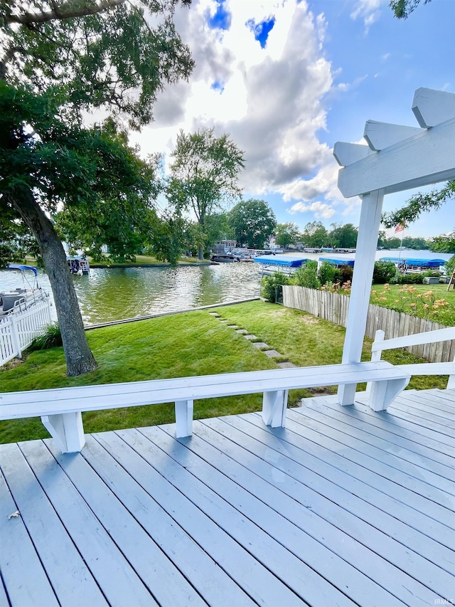 wooden deck with a yard and a water view