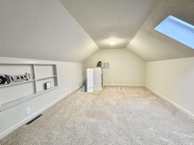 bonus room featuring carpet flooring, a textured ceiling, vaulted ceiling, and built in features