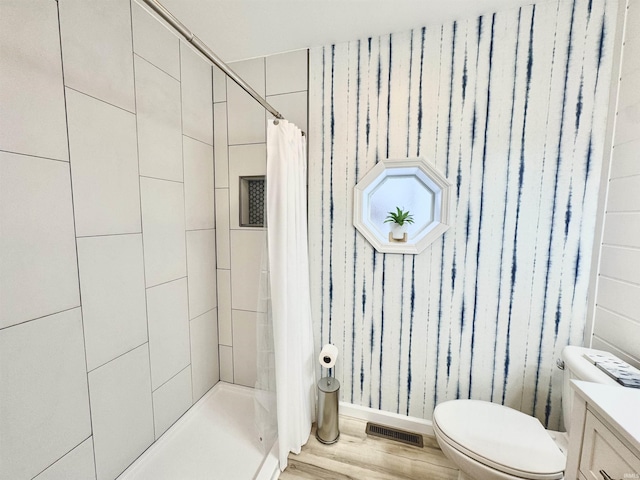 bathroom featuring vanity, hardwood / wood-style flooring, toilet, and walk in shower