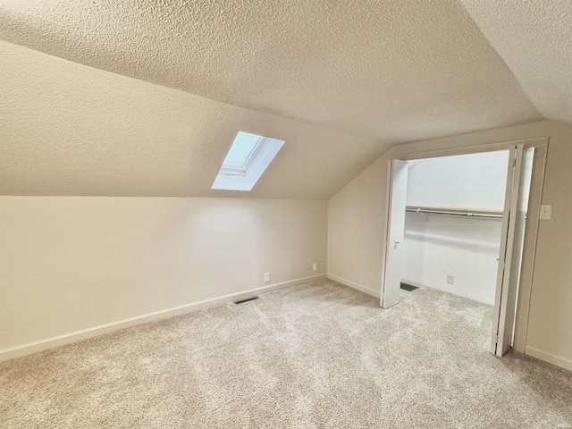 bonus room featuring a textured ceiling, light colored carpet, and vaulted ceiling