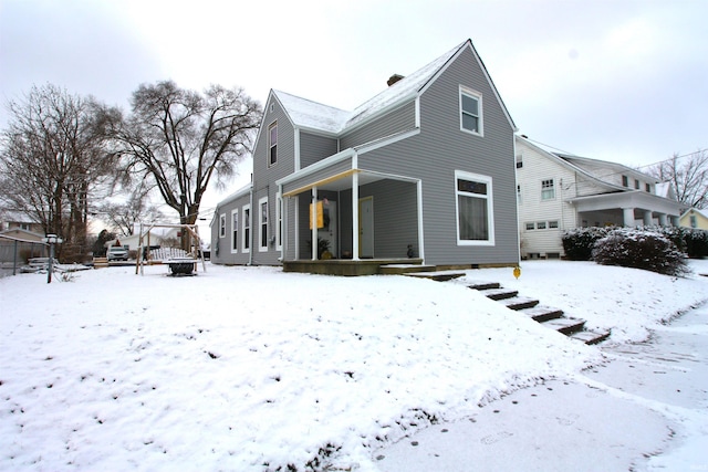 snow covered property with a porch