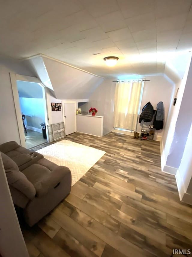 bonus room with hardwood / wood-style floors and vaulted ceiling