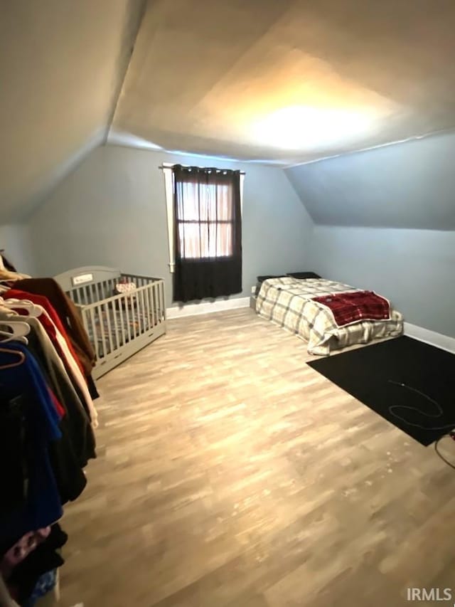 bedroom featuring lofted ceiling and wood-type flooring