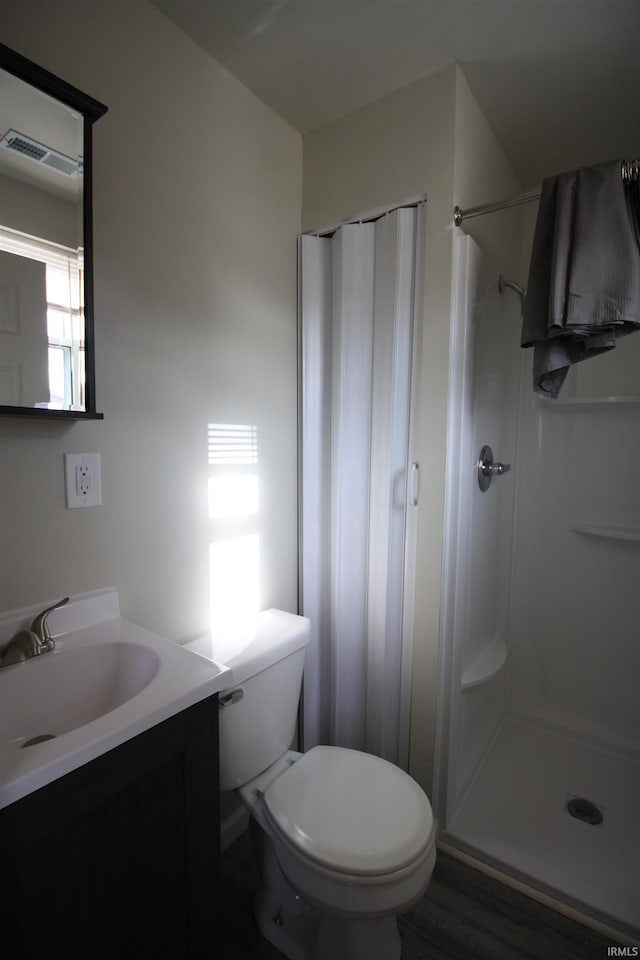 bathroom featuring walk in shower, vanity, and toilet