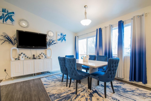 dining space with hardwood / wood-style flooring and vaulted ceiling