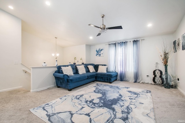 living room featuring ceiling fan with notable chandelier and carpet floors