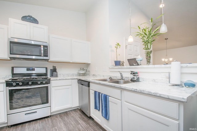 kitchen with white cabinets, appliances with stainless steel finishes, hanging light fixtures, and sink