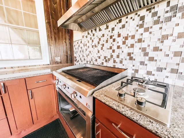 kitchen featuring tasteful backsplash, light stone countertops, and appliances with stainless steel finishes