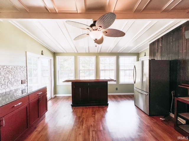 kitchen with a center island, ceiling fan, stainless steel fridge, and dark wood-type flooring