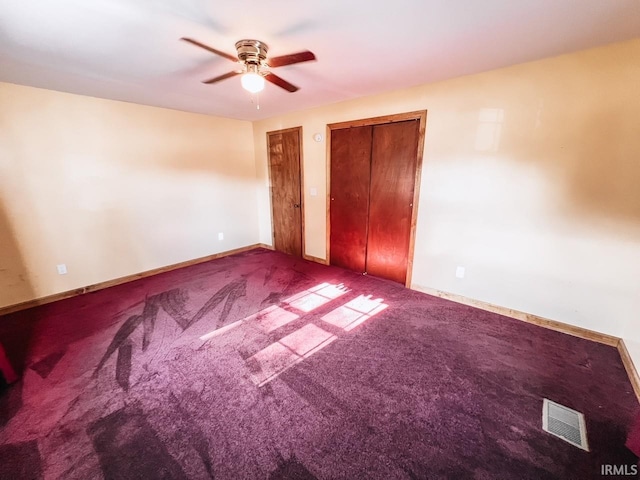 unfurnished bedroom with multiple closets, ceiling fan, and carpet