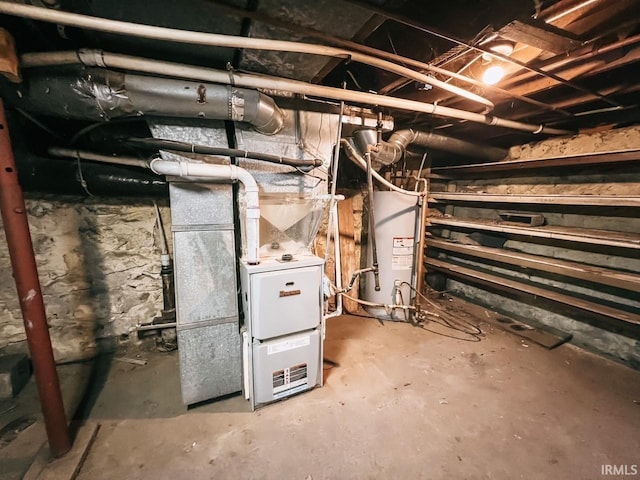 utility room featuring heating unit and water heater