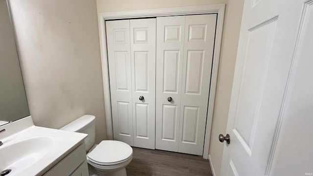 bathroom featuring vanity, hardwood / wood-style flooring, and toilet